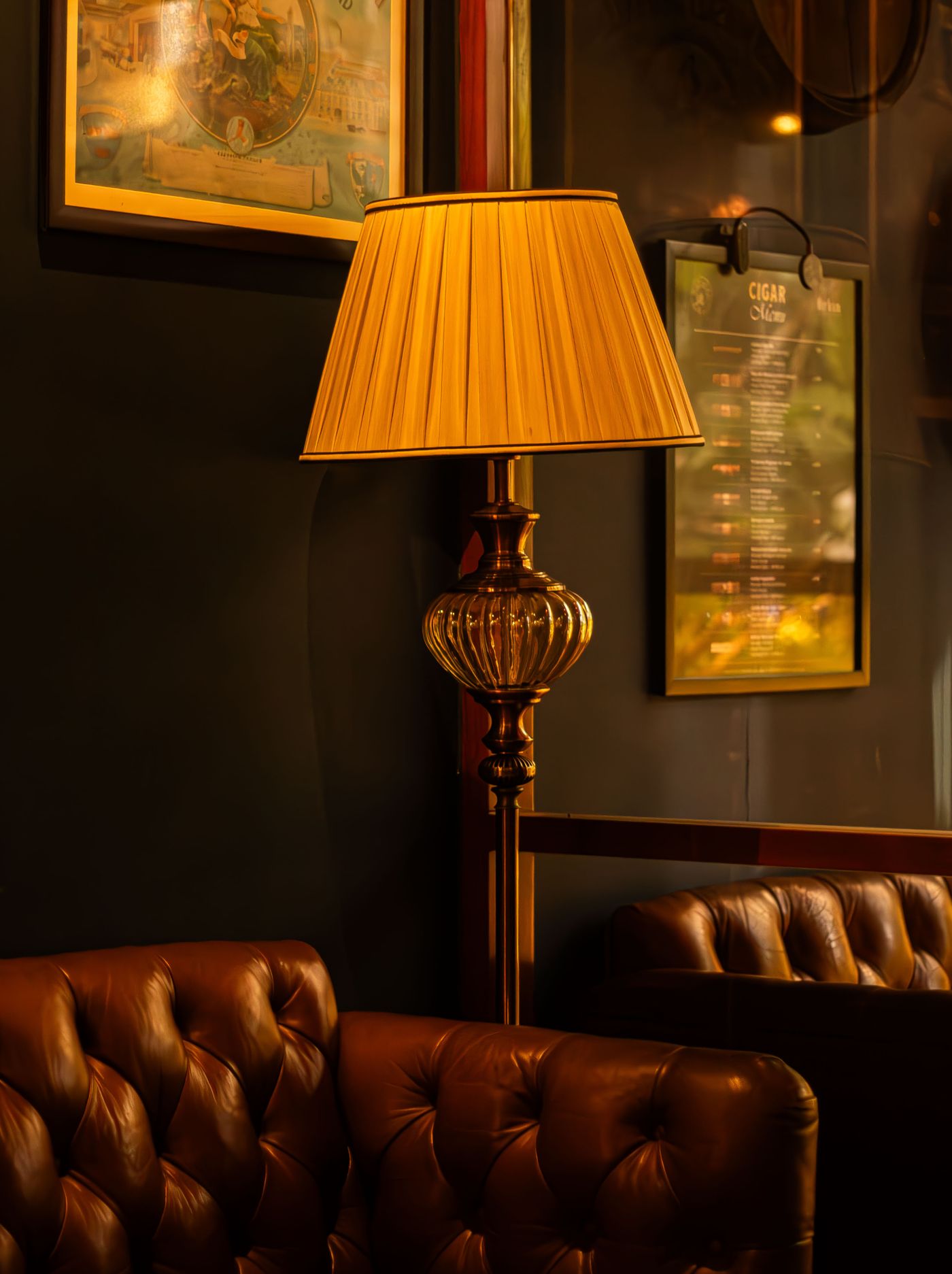 Upscale cigar lounge interior with warm lamp light and tufted leather seating